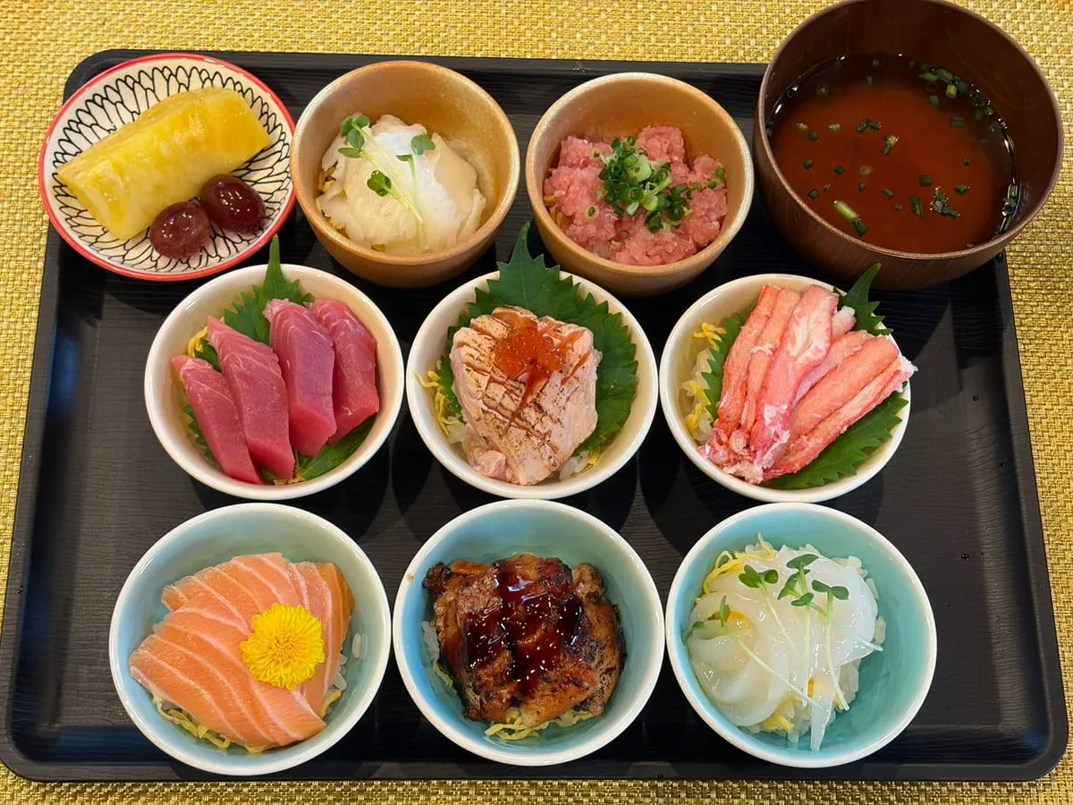 KAGAYAKI 〜8種の海鮮小鉢 - 8種の海鮮小鉢と汁物、果物が並ぶランチのお盆